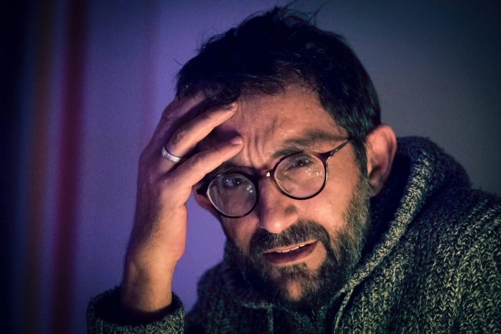 Man holding his head in one hand as he questions the meaning of preventive health.