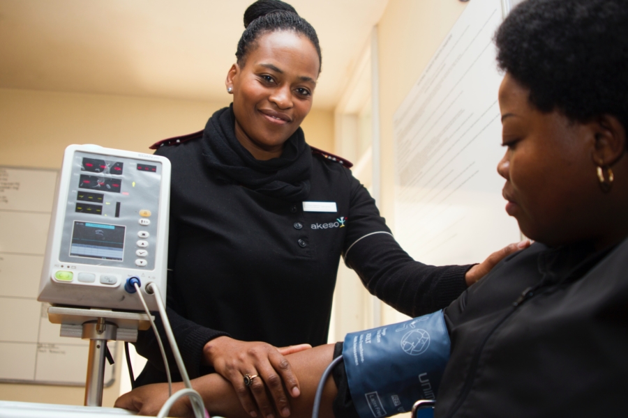 Doctor comforting female patient who is being monitored for hypertension.