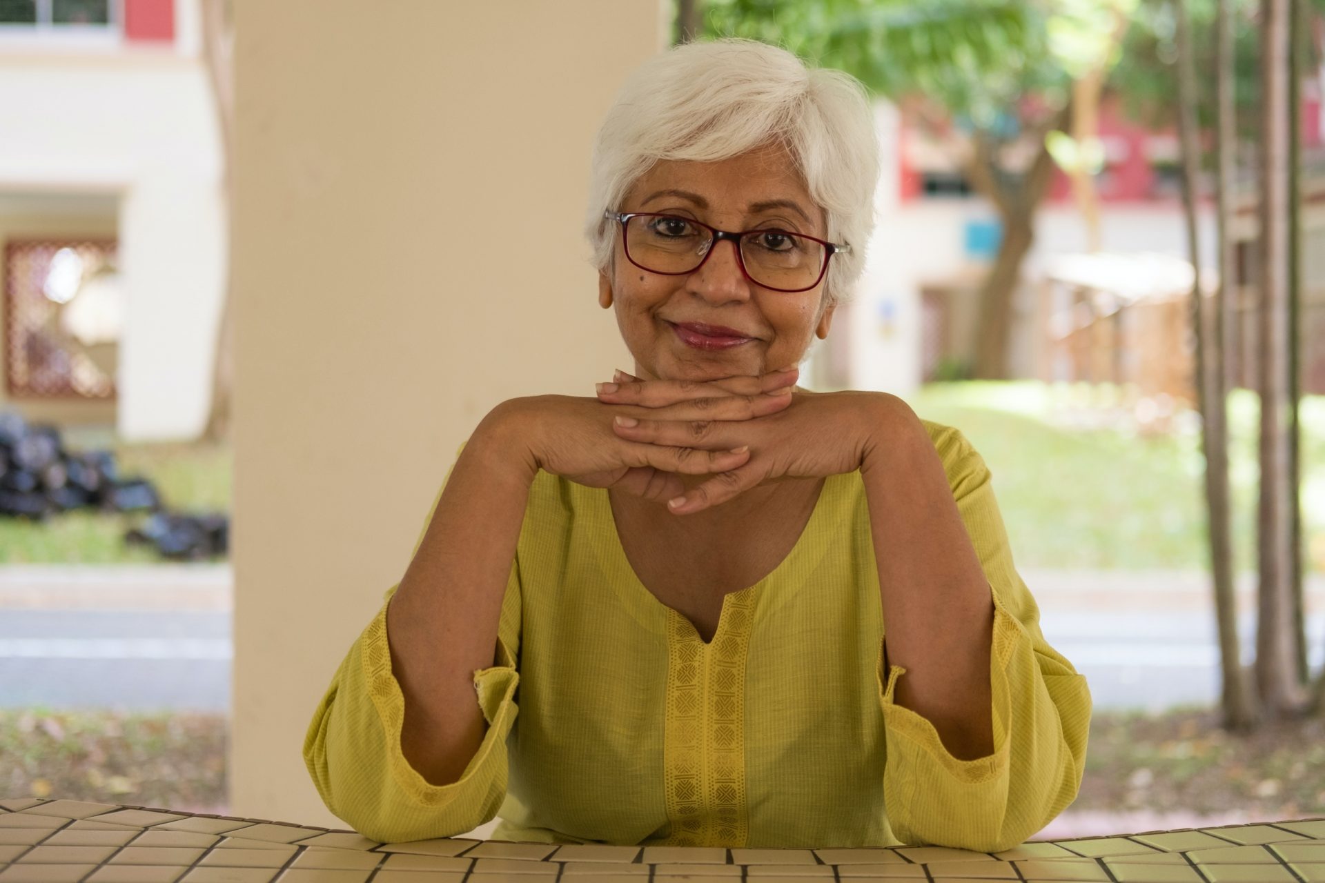 Youthful looking gary-haired woman smiling and looking confident.