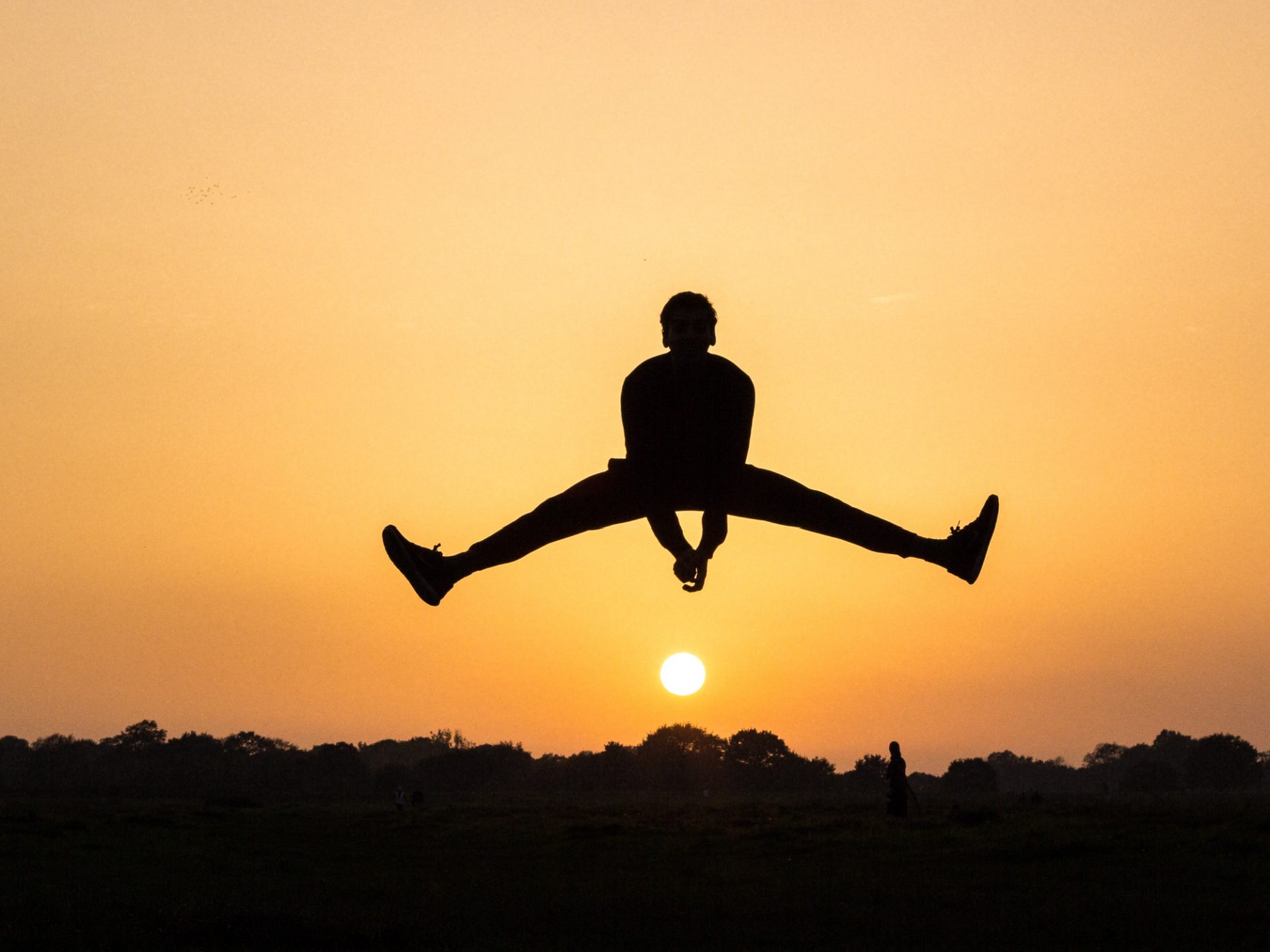 Man appearing to jump over the sun in joy because he's cured from a chronic disease.