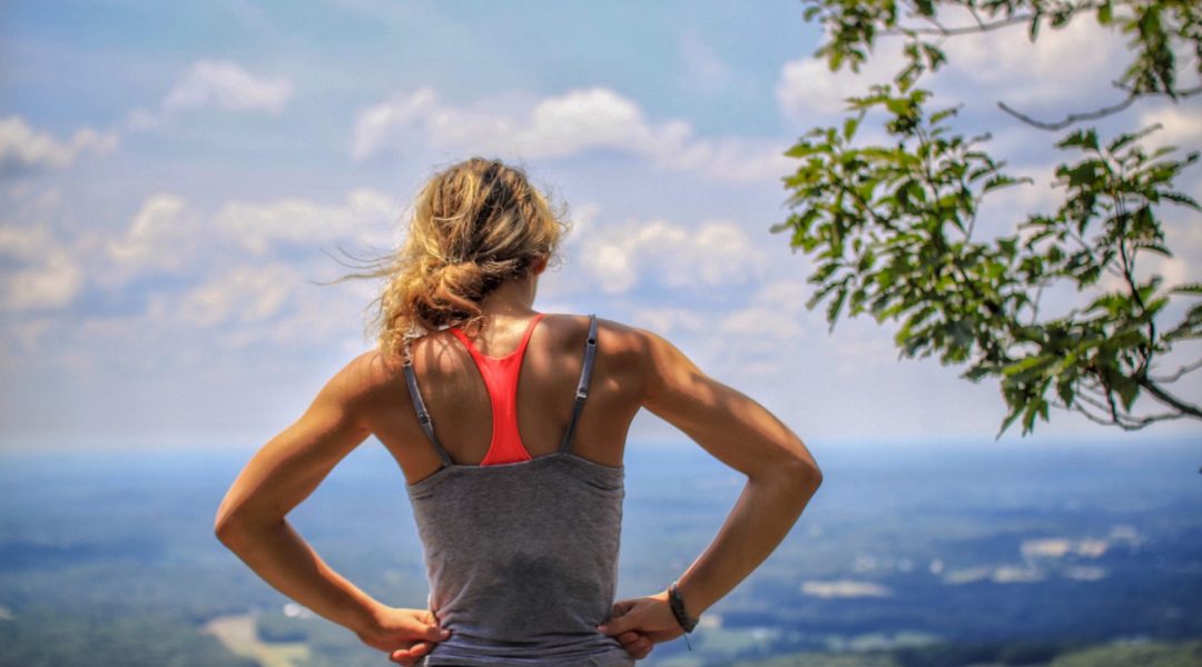 Fit woman looking out over a valley.