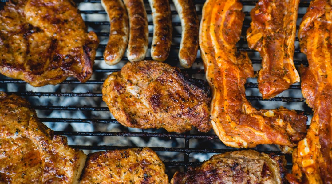 A variety of meats on a grill.