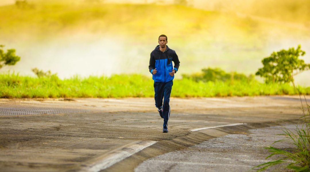 Man jogging on a road in the countryside.