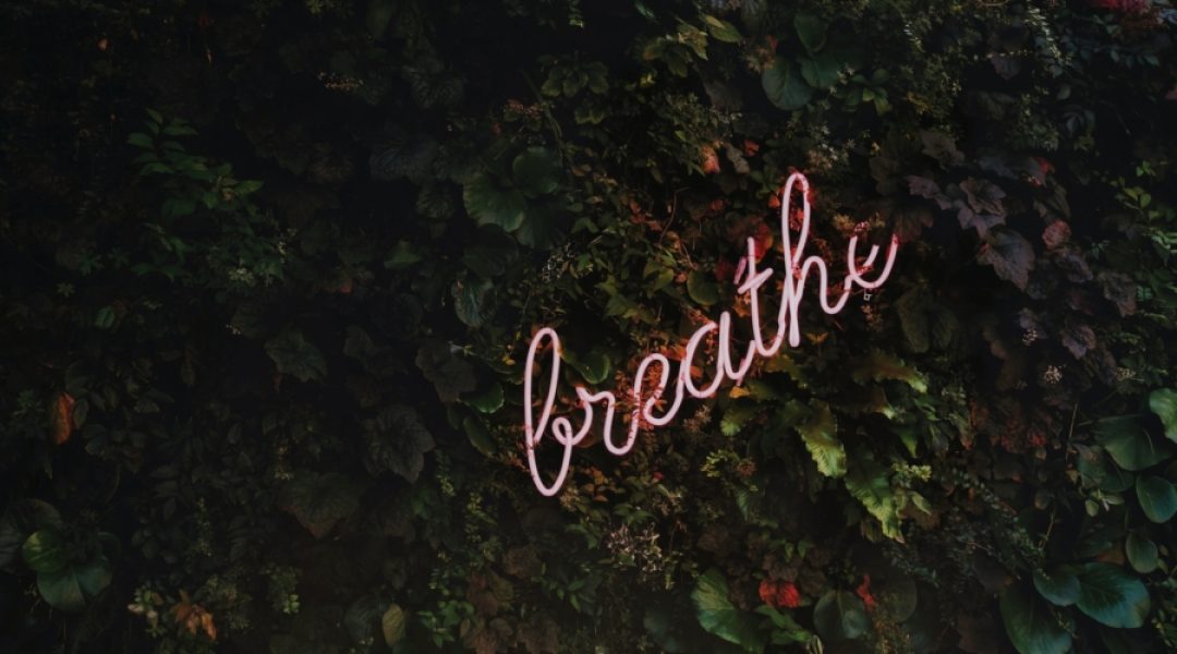 Fluorescent sign reminding us to breathe which is a effect natural anti-anxiety remedy.